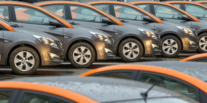 Viele Fahrzeuge eines Carsharing-Anbieters stehen auf einem Parkplatz