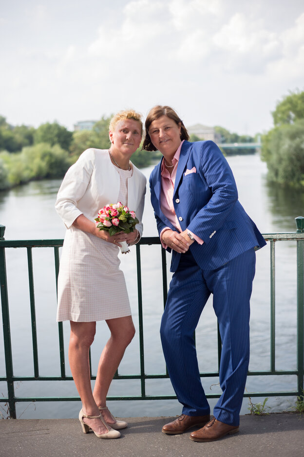 Zwei Frauen stehen zueinendergeneigt auf einer Brücke und lächeln in die Kamera Zwei Frauen stehen zueinendergeneigt auf einer Brücke und lächeln in die Kamera