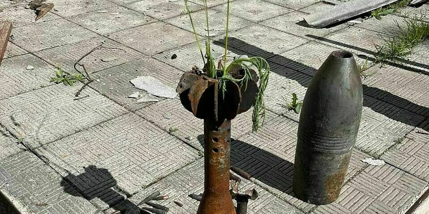 Gräser stecken in dem Kopf einer Granate - die auf einer beschädigten "Terrasse" steht