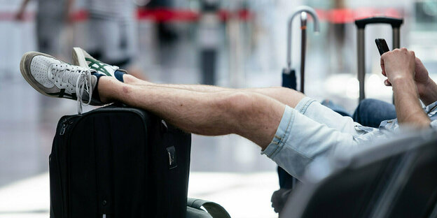 Männerbeine auf einem Koffer