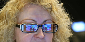 Putin spiegelt sich in den Brillengläsern einer Frau