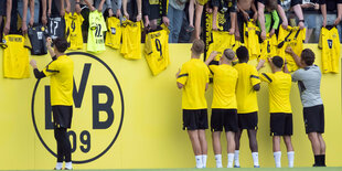 BVB-Trainer Terzic und einige Spieler schreiben Autogramme.