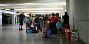 Eine Menschengruppe am Bahnhof