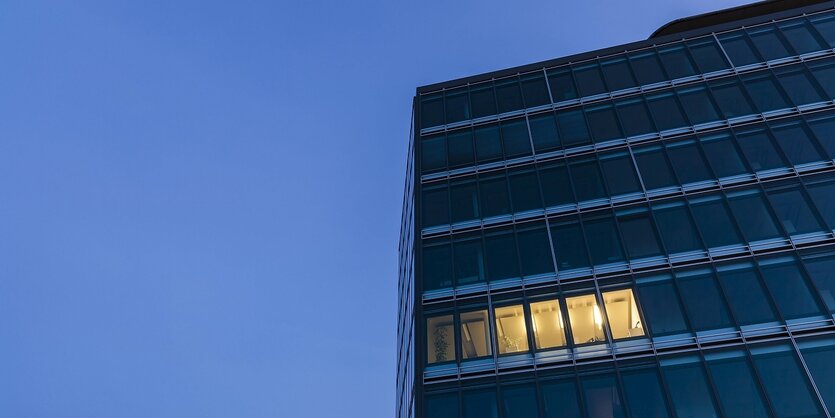 Ine einem Bürohochhaus brennt spätabends noch Licht