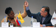 Gustavo Petro und Francia Marquéz fassen sich aus Freude über ihen Wahlsieg an jeweils einer erhobenen Hand.