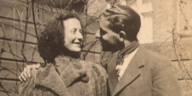 Sepiafarbene Fotografie aus dem Jahr 1942. Sie zeigt ein Liebespaar in Wintermänteln, das sich anlächelt