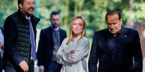 Matteo Salvini, Giorgia Meloni und Silvio Berlusconi stehen in unterschiedlichen Posen nebeneinander