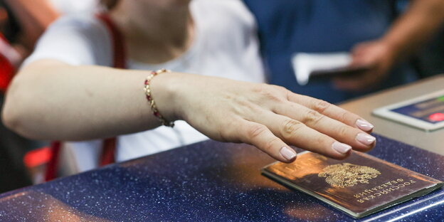 A woman holds a hand over a Russian passport