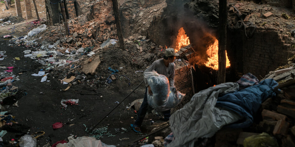 Ein Arbeiter verbrennt Plastiksäcke in einem Brennofen in Kambodscha