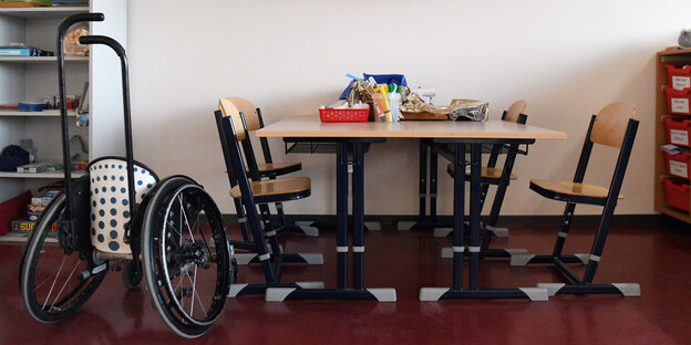 Rollstuhl steht neben Schultisch