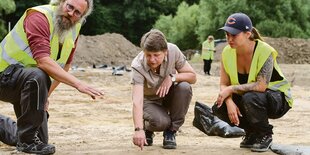 Grabungsleiter Leif Schlisio, Abteilungsleiterin Ingrid Sudhoff und die Projektstudentin Katharina Schreiber an der Fundstelle eines 2000 Jahre alten Tontopfs.