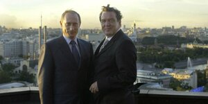 Putin und Schröder posieren vor einer Stadtkulisse
