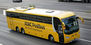 Ein ADAC-Postbus auf einer Autobahn.