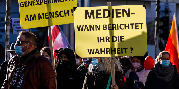 In einer Demonstration trägt eine Teilnehmerin ein gelbes Schild mit der Aufschrift: "Medien. Wass berichtet ihr die Wahrheit?"