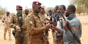 Ein Offizier begrüßt Soldaten vor einem gelben Wüstenhintergrund