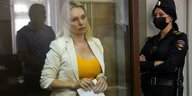Die Journalsitin Owsjannikowa steht in einem Gericht in Moskau hinter einer Scheibe. In der Hand hält sie ein gefaltetes Papier.