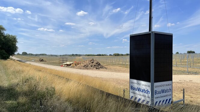 Baustelle des Solarparks Döllen, im Vordergrund ein Schild: „Geschützt durch BauWatch“