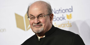 Salman Rushdie, im Hintergrund der Schriftzug „National Book Awards“