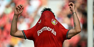 Ein Spieler von Bayer Leverkusen zieht sich sein Trikot übers Gesicht