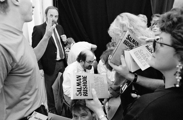 Salman Rushdie auf einem Schwarzweißfoto, umringt von Menschen, die sein Buch "Die satanischen Verse" signiert haben wollen Salman Rushdie auf einem Schwarzweißfoto, umringt von Menschen, die sein Buch "Die satanischen Verse" signiert haben wollen