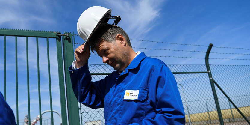 Robert Habeck mit Helm in der Hand beim Besuch eines Gasspeichers in Bad Lauchstädt