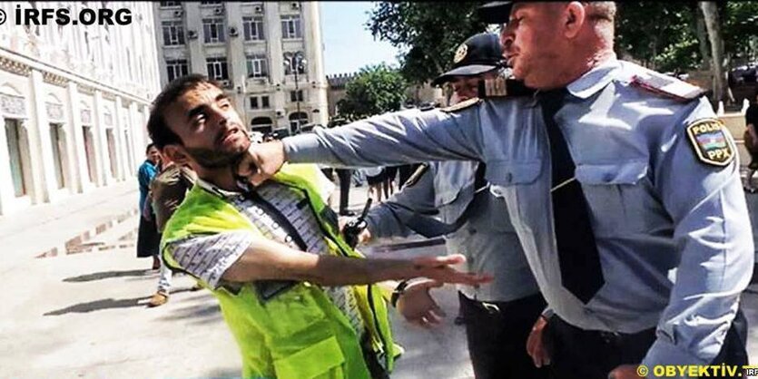 Ein Mann in Uniform verpasst einem bärtigen Mann einen Kinnhaken