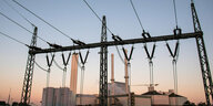 Stromverteiler und Stromleitungen stehen im Licht der aufgehenden Sonne vor dem Heizkraftwerk Tiefstack.