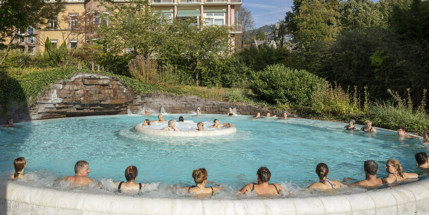 Menschen sitzen in einem großen Pool im Thermalbad