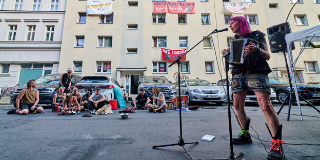Demonstrant*innen lauschen einem Musikbeitrag vor dem Obdachlosen-Hausprojekt in der Habersaathstr. 40-48