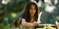 Kya, die Protagonistin im Wald mit einer Feder in der Hand