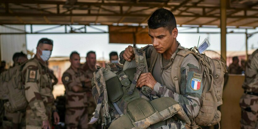 Ein Französischer Soldat schultert einen Rucksack