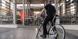 Ein Mann fährt in ein Fahrradparkhaus