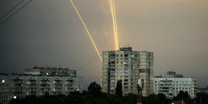 Leuchtspuren von Raketen über Plattenbauten in Charkiw