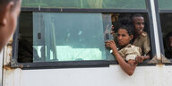 uniformierte Menschen schauen aus dem Fenster eines Busses