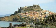 Eine Stadt am Hang auf Sardinien, davor das Meer