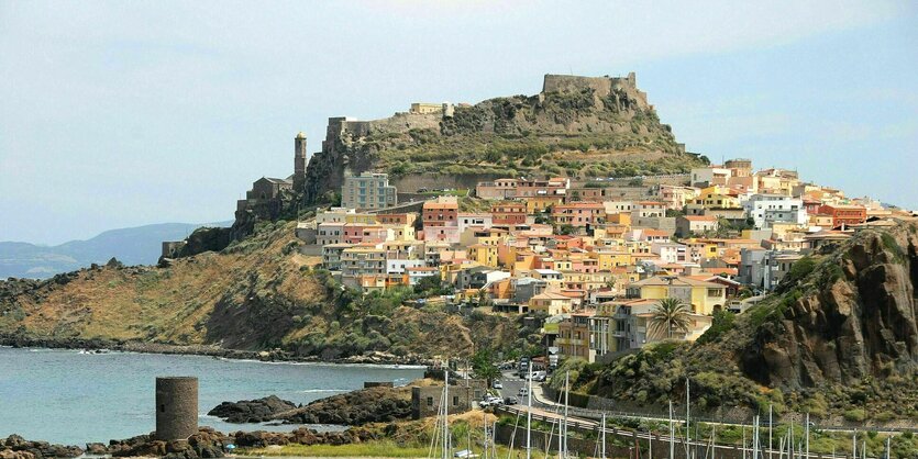 Eine Stadt am Hang auf Sardinien, davor das Meer