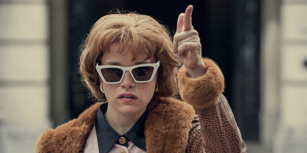 Szene aus der Serie: Kleo (Jella Haase) mit Sonnenbrille, die Hände zur Pistole geformt