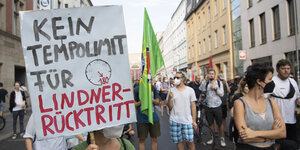 Teilnehmer an der Demonstration "Lindner raus - Umverteilung jetzt!" stehen mit Plakaten an der FDP-Bundesgeschäftsstelle. Auf dem Plaket steht "Kein Templimit für Lindner-Rücktritt"