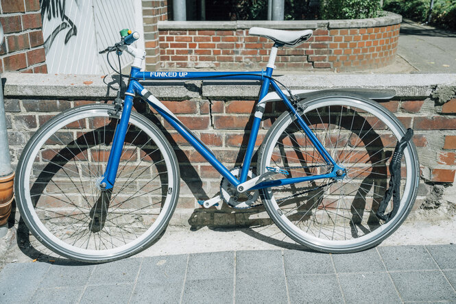 Ein blaues Fahrrad steht an einer Mauer