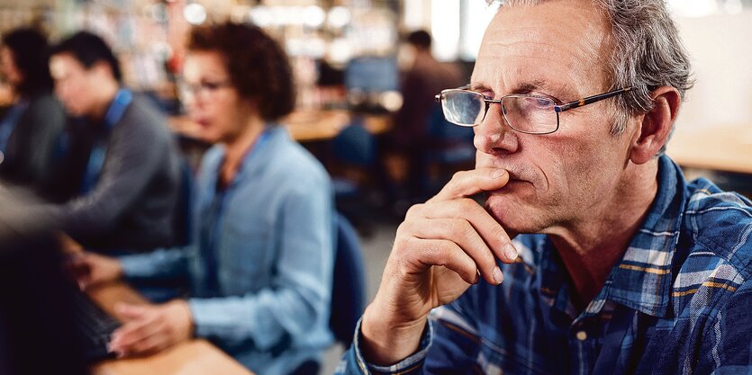 Drei Personen sitzen am Computer und gucken konzentriert