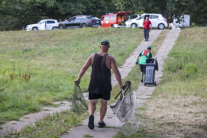 Männer mit Fischnetzen gehen auf einem Weg