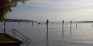 Jungen balancieren auf Pfählen im See