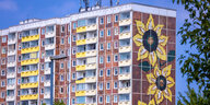 Der ikonische braun-beige Plattenbau in Rostock-Lichtenhagen mit dem Sonnenblumenmosaik auf der Brandwand