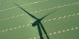 Windrad auf grüner Wiese im Schatten