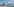 Bild eines Strandes mit Badegästen, im Hintergrund steigt eine riesige Rauchsäule in den Himmel