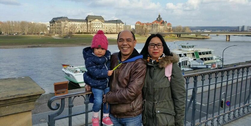 Ein Familienfoto der Sons vor einem Fluss in einer Stadt.