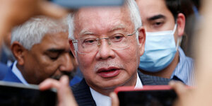 Najib Razak spricht in von Reportern hingehaltene Mobiltelefone.