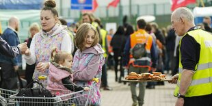 Ein Mädchen schaut zu Butterbroten, die ihr gereicht werden