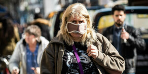 Eine Frau trägt eine Schlafmaske als Schutzmaske auf der Straße