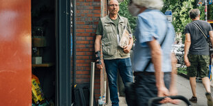 Straßenzeitungsverkäufer Thomas Audörsch steht am Eingang eines Hamburger Supermarkts